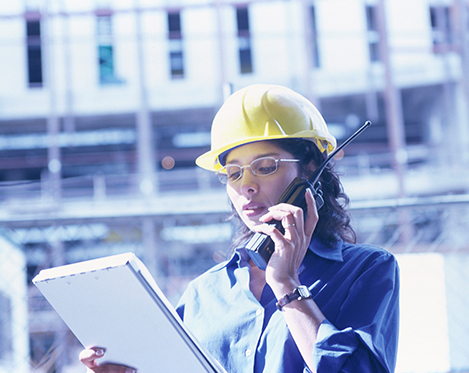 Woman construction worker on the phone at construction site