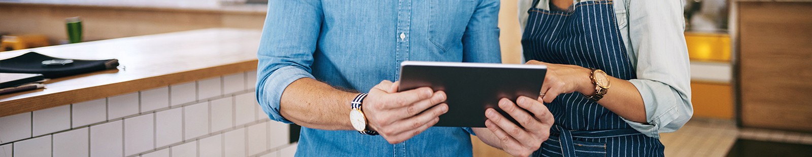 Man and woman pointing at tablet device