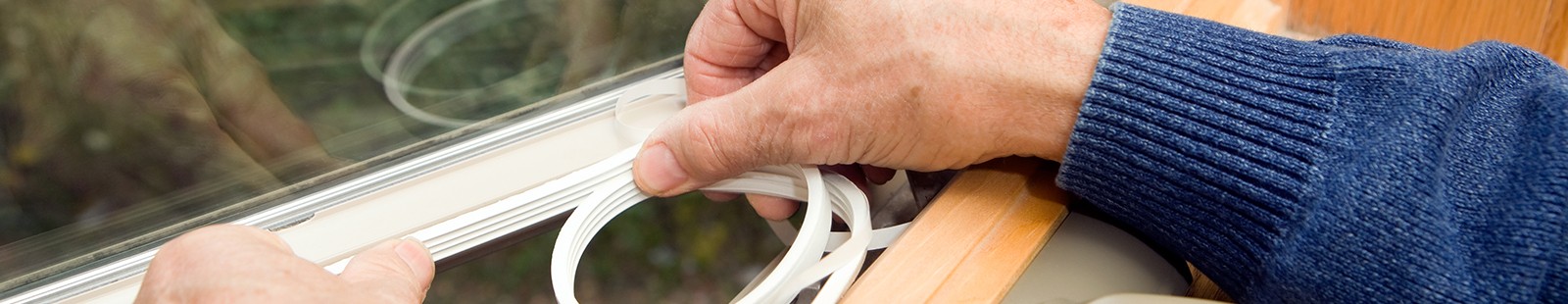 Hand adding insulation to window