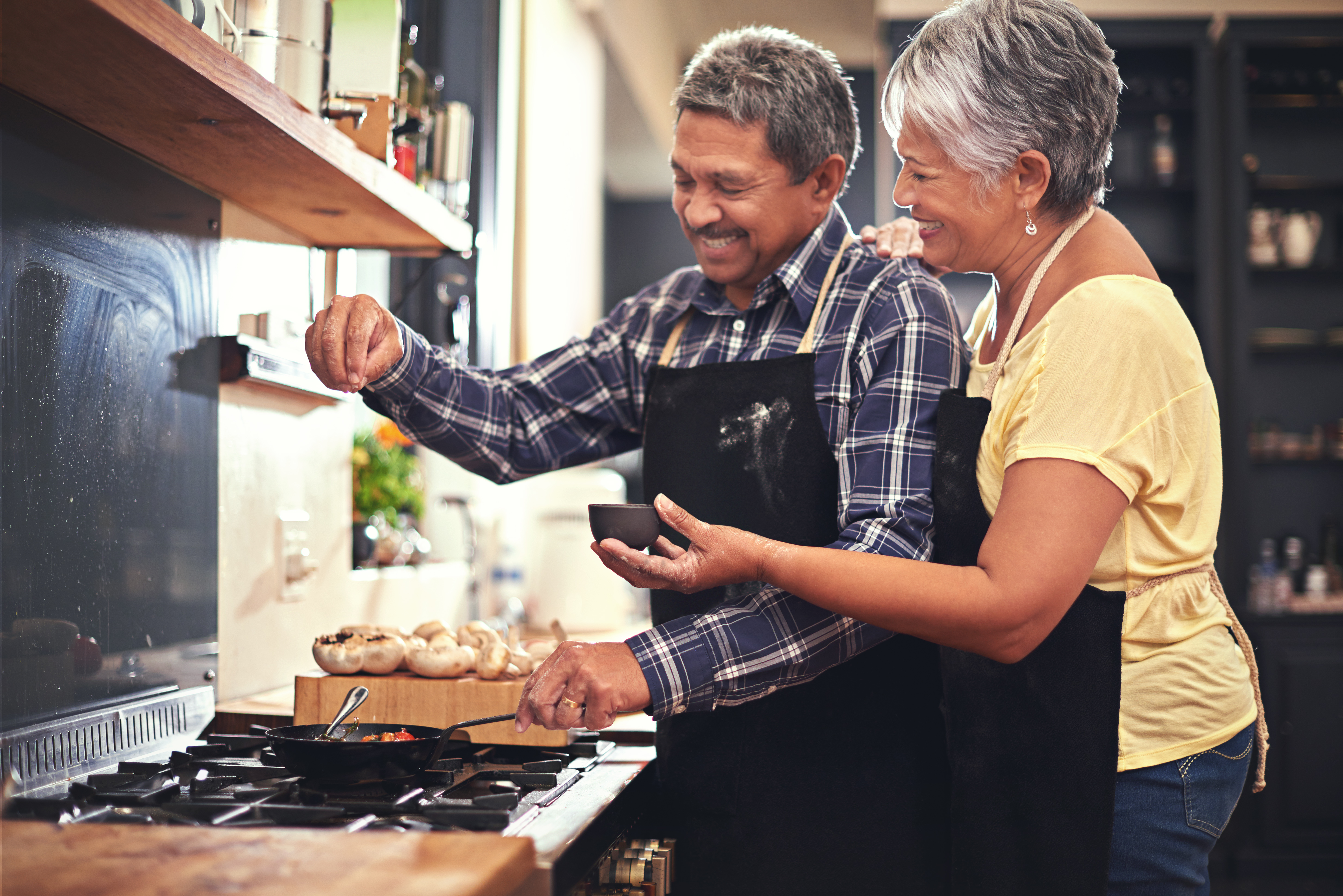 Older couple cooking in front of stovetop