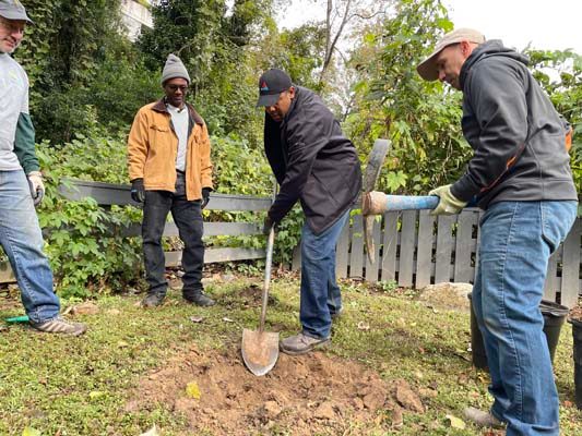 Atlanta Gas Light Vice President of Operations Dean Marianos loosens soil with a pick while Region Director Cordell Carter and Piedmont Enhancement Project Manager Thomas Wideman take turns moving the soil to buckets.