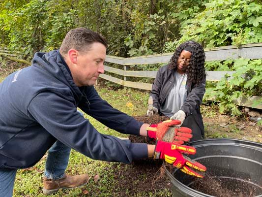 Atlanta Gas Light Construction Manager Justin Weaver and Senior Administrative Assistant Syreeta Campbell break up the roots to give them a fresh start on growth.