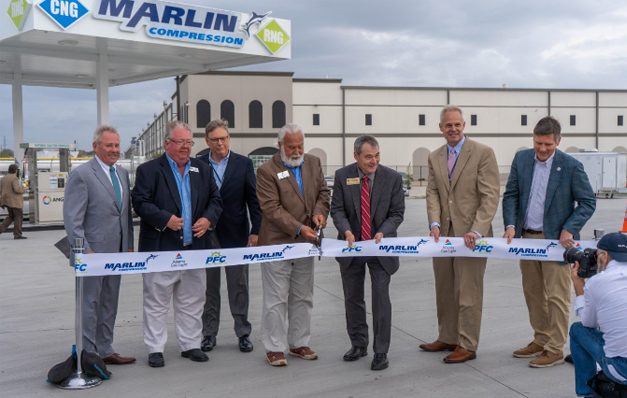 group of men cutting a ribbon